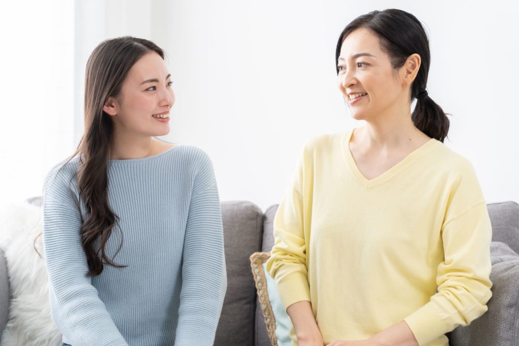 20代と40代の女性2人が笑顔で話している様子