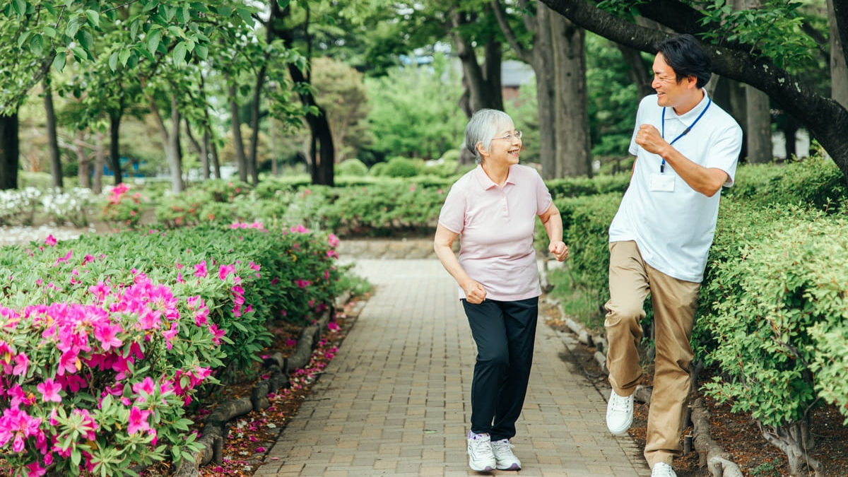 Elderly people and male staff walking