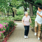 Elderly people and male staff walking