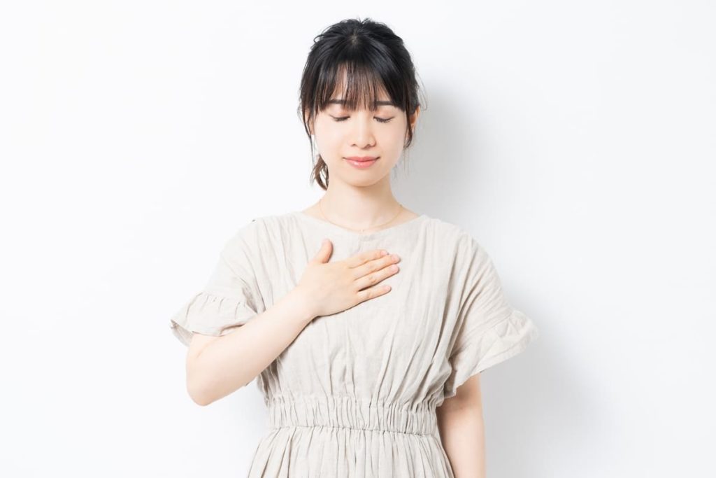 胸に手を当てる女性