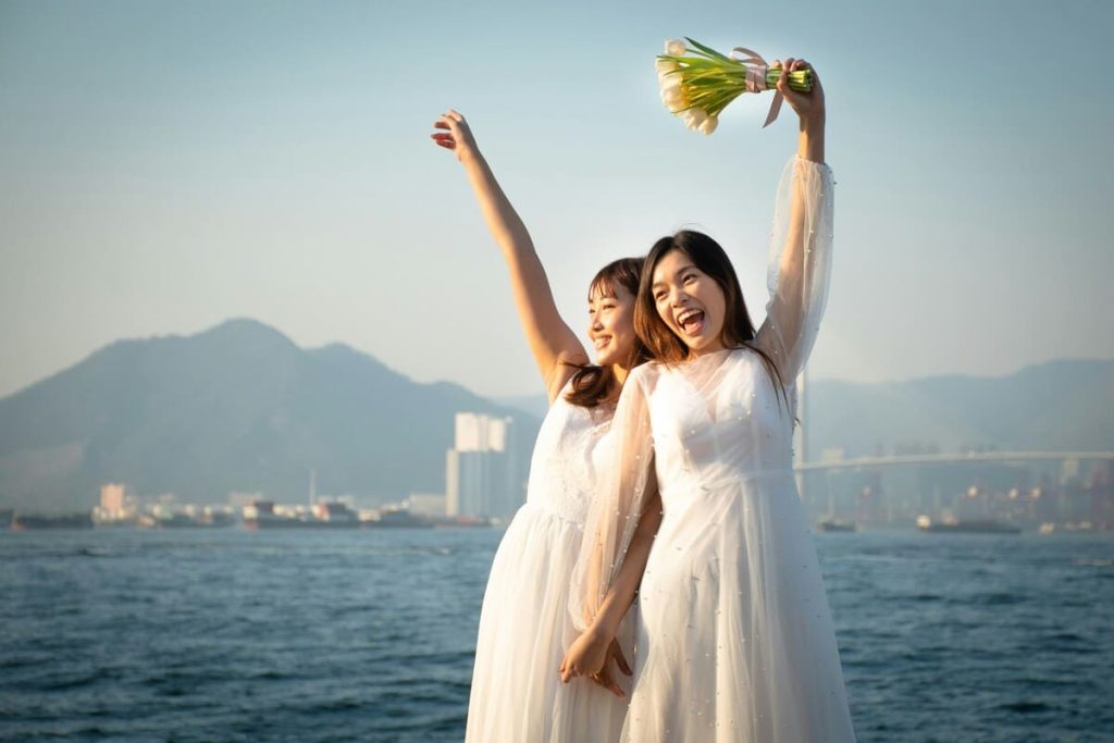 黄色と緑の花を持つウェディングドレスを着た2人の女性
