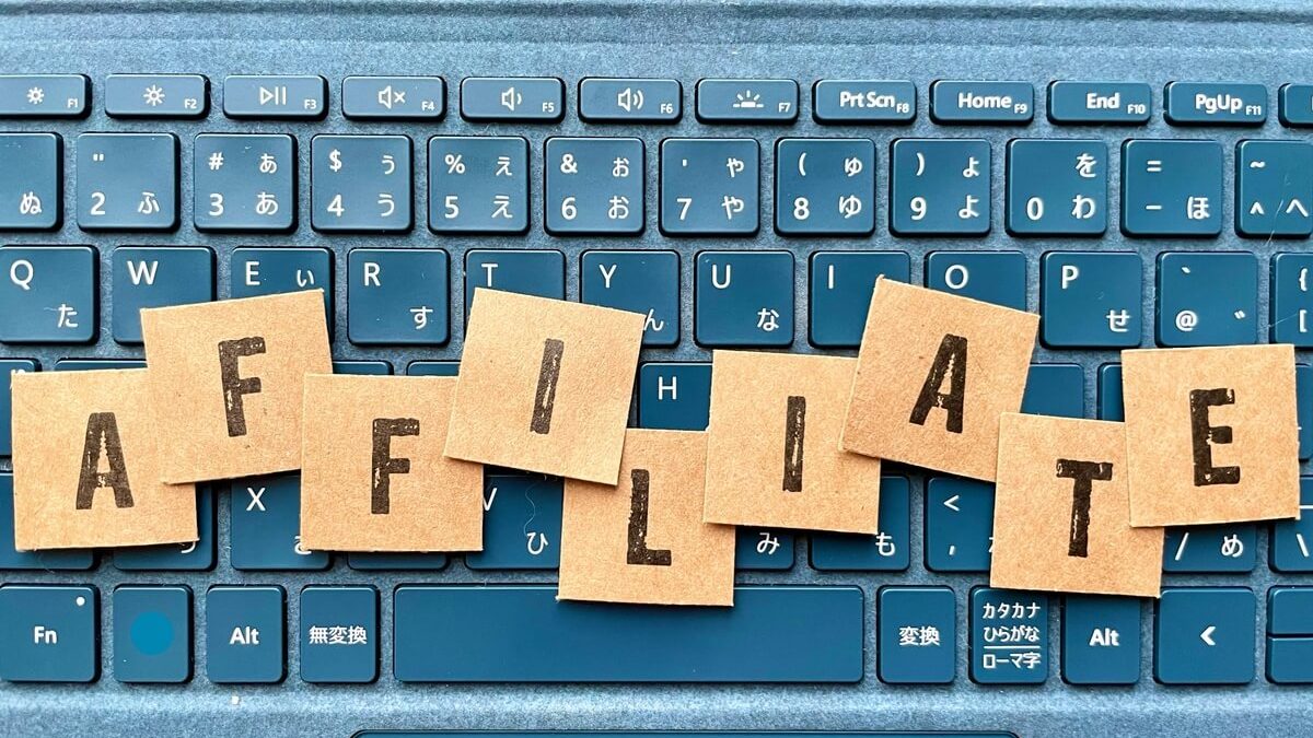 Scrabble-style tiles spelling "AFFILIATE" arranged on a blue keyboard background, symbolizing affiliate marketing or online work.
