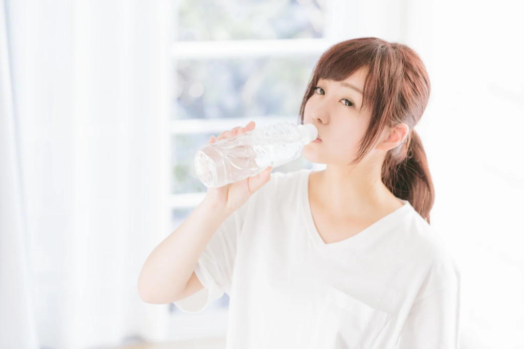 モーニングルーティンを行う女性、朝起きて水を飲む女性