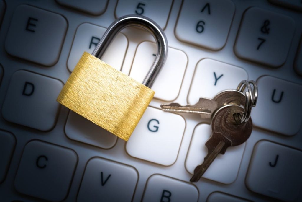 キーボードの上に置かれた南京錠と鍵のセット。サイバーセキュリティやデータ保護を象徴するイメージ。