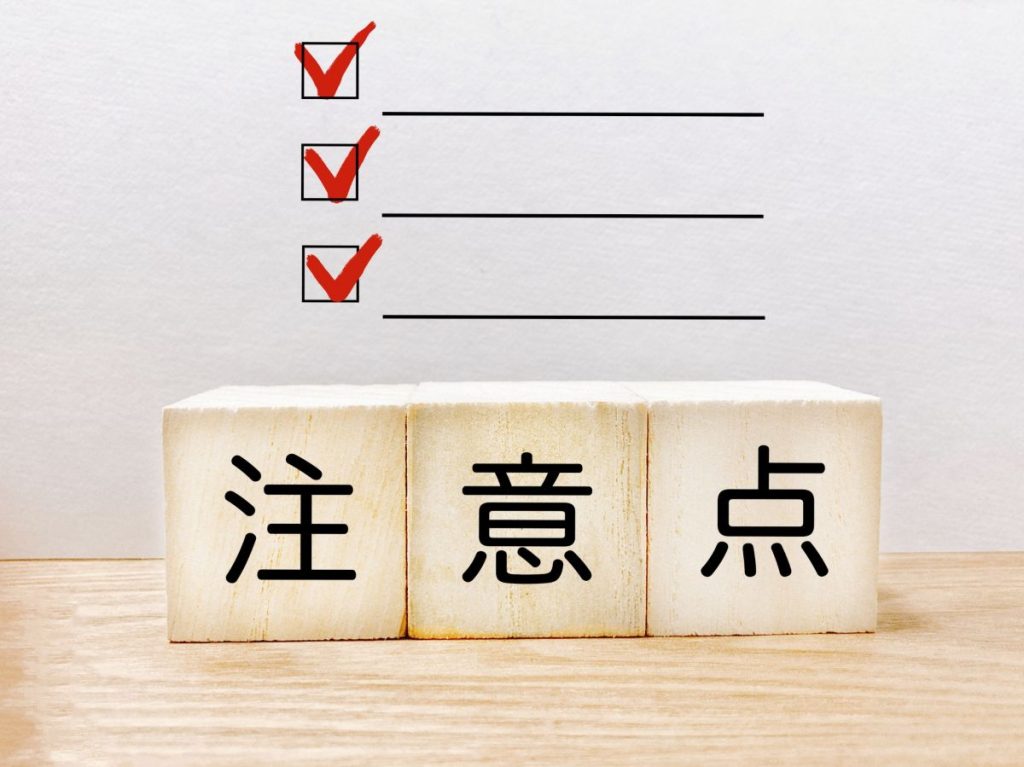 3つの赤いチェックマークと、「注意点」と書かれた木のブロックが並んでいる画像。