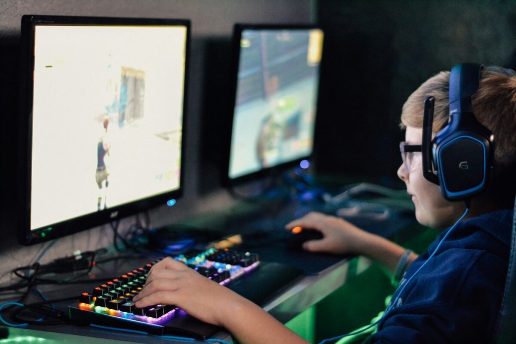 eスポーツバーでプレイする男性、ゲーミングPCでゲームをする男性