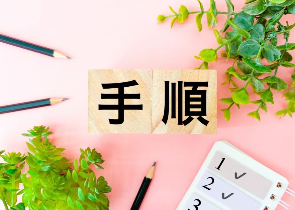 机の上に置かれた木製のブロックに「手順」と書かれたメモの画像。