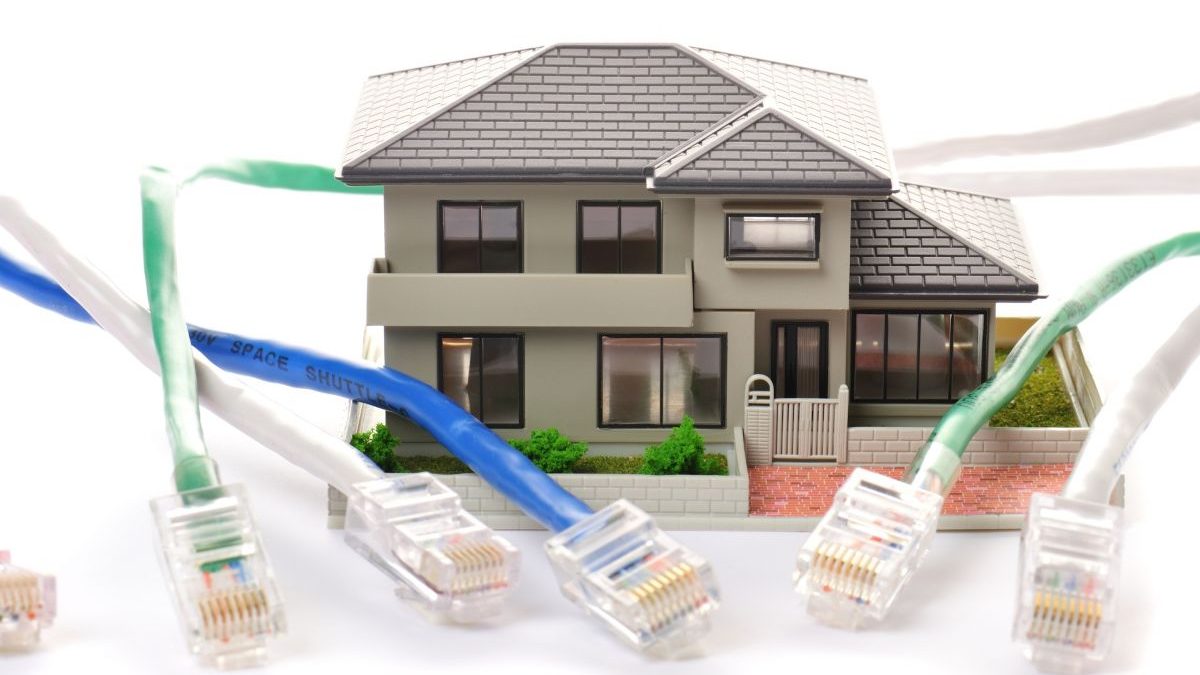 A photo showing multiple LAN cables connected to a model house.