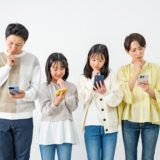 A family of four looking at their smartphones with thoughtful expressions. Represents concerns about internet setup or choosing a broadband service.