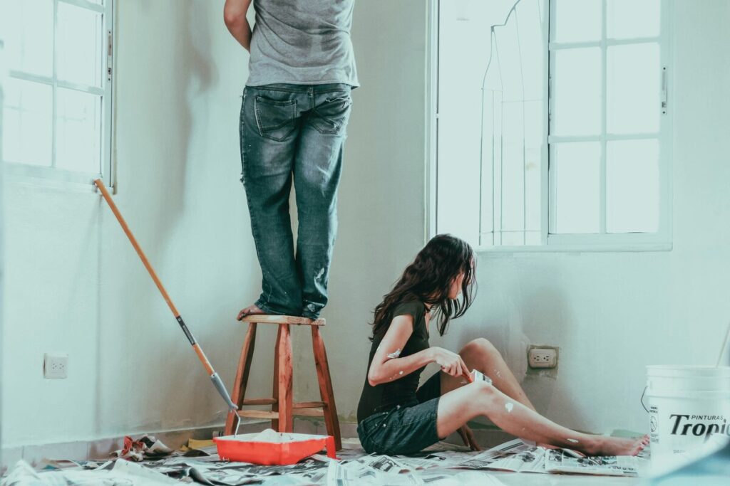 DIYをする男女、部屋のペンキを塗り直す