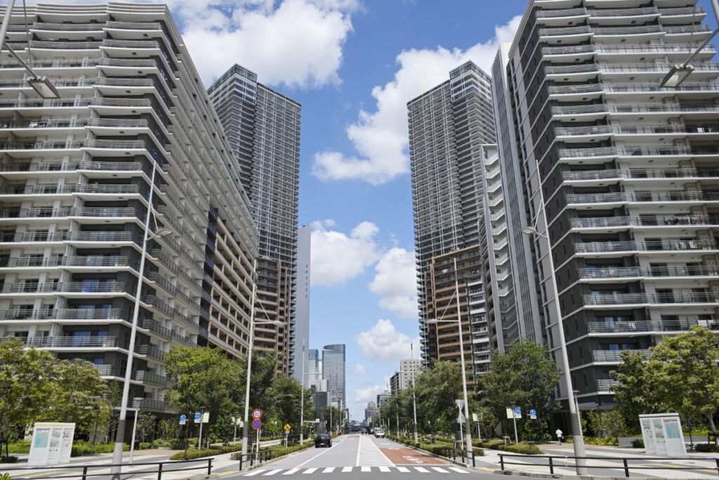 都市部に並ぶ高層マンション群と広い道路。近代的で利便性の高い住環境をイメージさせる景観。