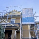A house with scaffolding set up for exterior painting or repairs.
