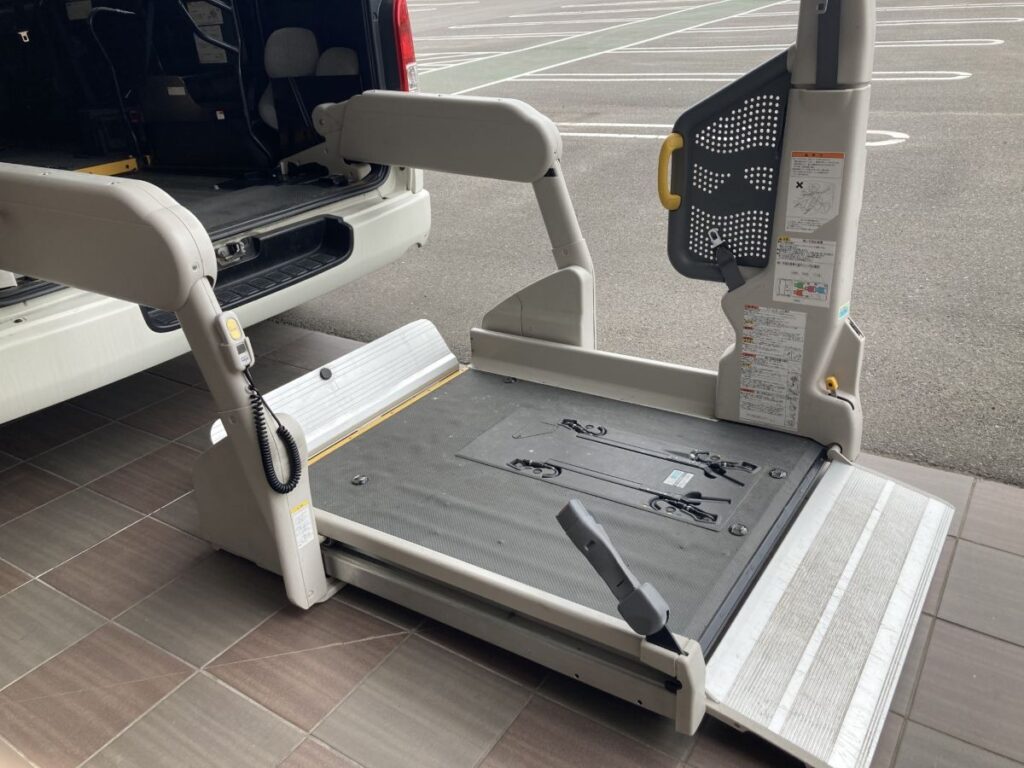 車いすの昇降が可能な福祉車両用リフトのクローズアップ。広いプラットフォームと安全ガード付き。