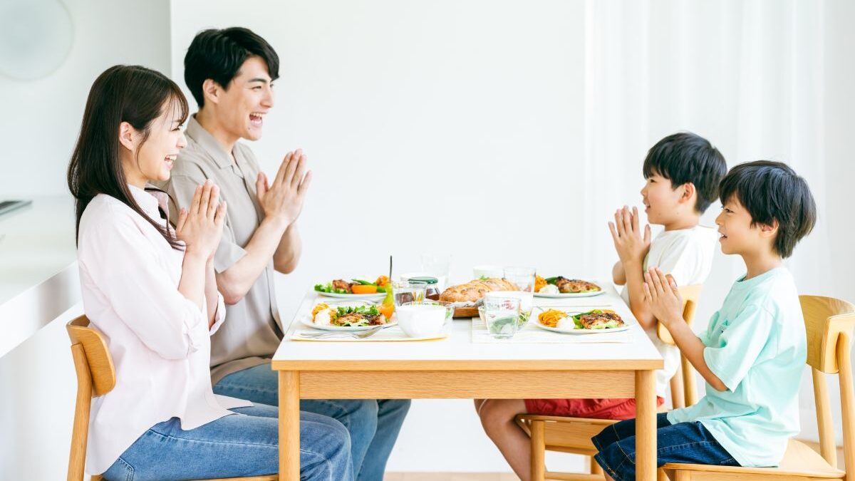 A family practicing shokuiku, smiling at the dining table and saying “Itadakimasu” to nurture health and happiness.