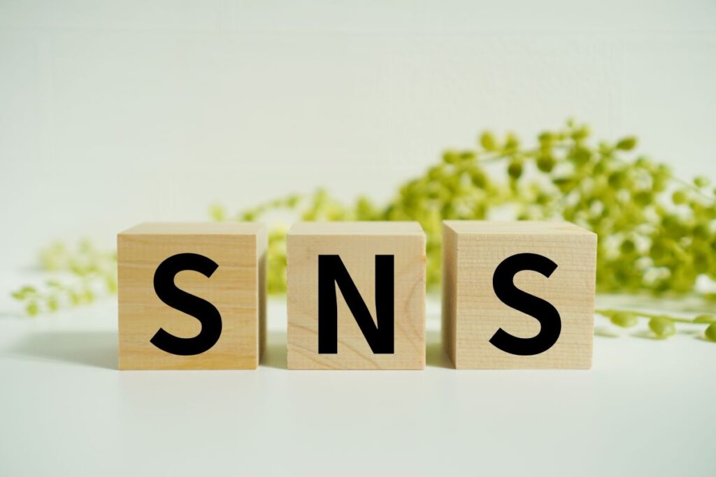 「SNS」と書かれた木製ブロックが並んでいる写真。SNSの利用やプロモーションを象徴するシンプルなイメージ。