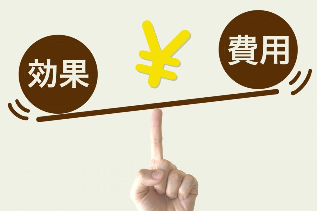 指先で支えられた天秤のイラストに「効果」と「費用」が描かれている画像。メンズVIO脱毛のコストパフォーマンスを表すイメージ。