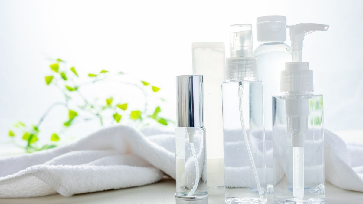 Moisturizing lotion and a clean towel representing skincare after men’s hair removal.