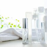 Moisturizing lotion and a clean towel representing skincare after men’s hair removal.