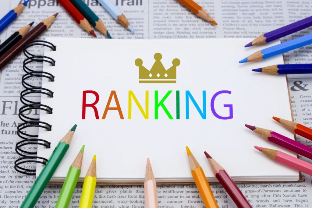 カラフルな鉛筆に囲まれたノートに「RANKING」と書かれ、アフィリエイトでトレンド情報を取り入れるイメージ。