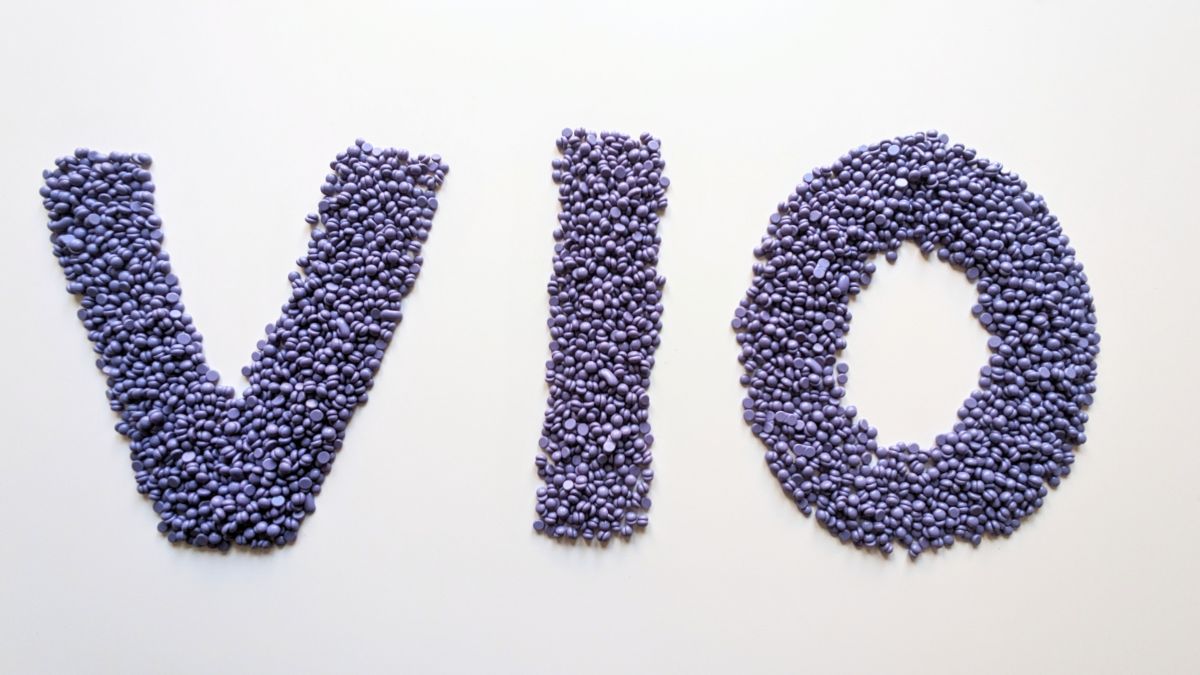 The word “VIO” formed with purple beads, symbolizing VIO hair removal and delicate zone care.
