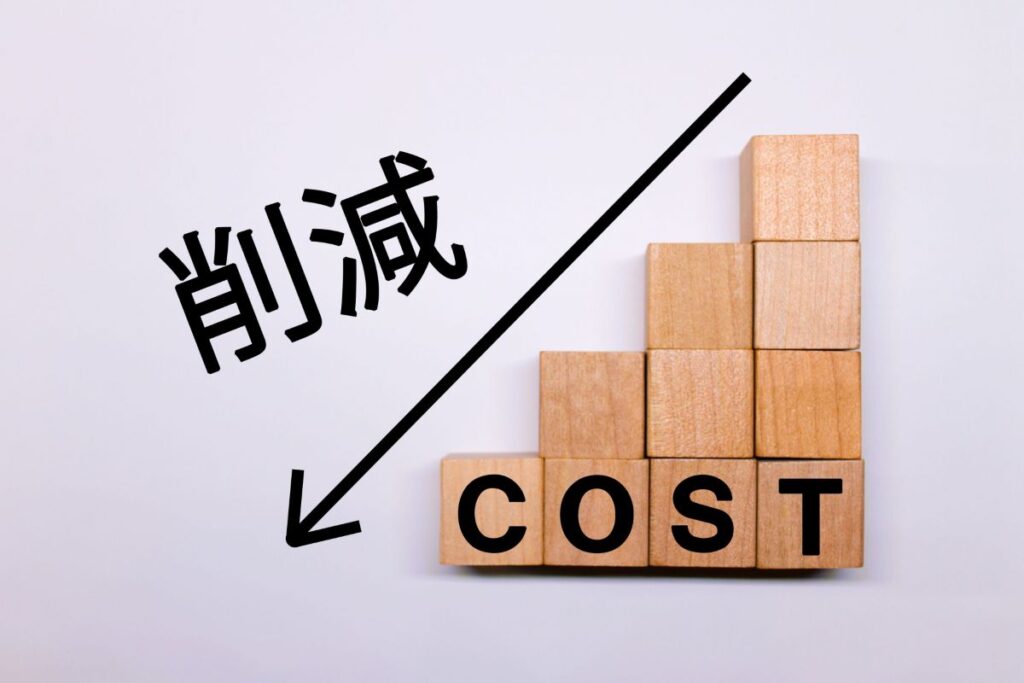 木のブロックで作られたグラフに「削減」と「COST」の文字が書かれた写真。コスト削減や経費見直しの重要性を示すイメージ。