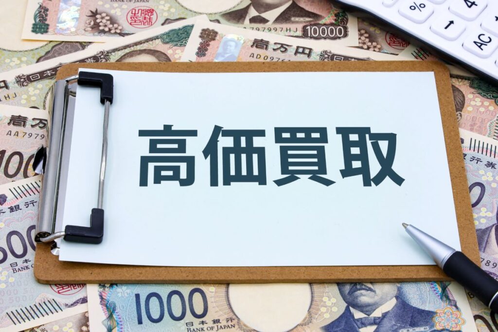 「高価買取」と書かれたボードが日本円紙幣の上に置かれている写真。中古トラックを高く売るイメージを伝える。