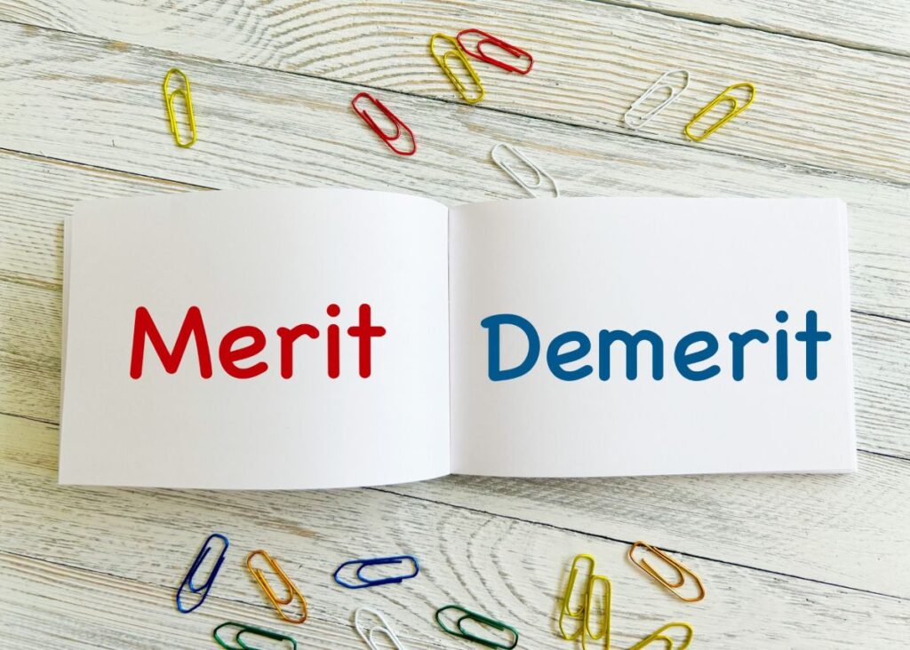 ノートに「Merit」と「Demerit」と書かれ、カラフルなクリップが散らばっている写真。脱毛のメリット・デメリットを説明するイメージです。