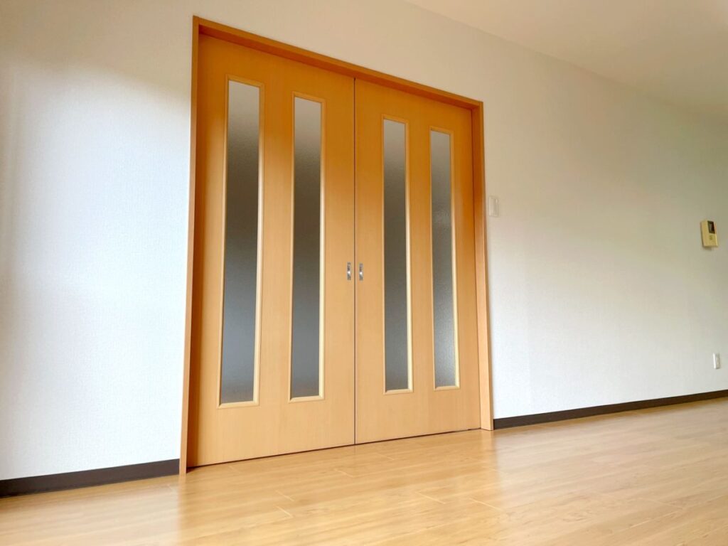 木目が美しい両開きの室内ドアの写真。ガラススリットが入り、モダンで温かみのあるデザイン。