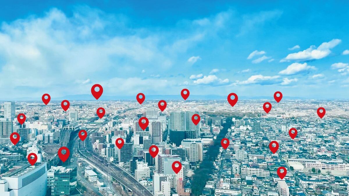 A cityscape with multiple red location pins representing local targeted advertising.