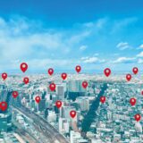 A cityscape with multiple red location pins representing local targeted advertising.