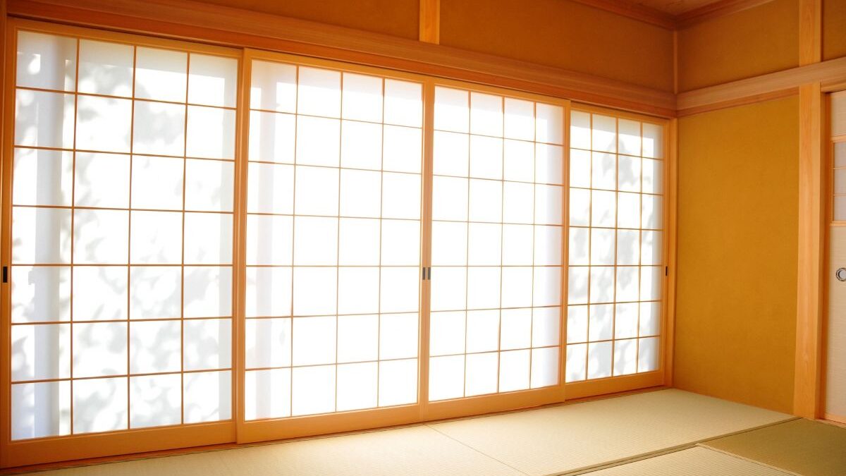 A photo of large sliding shoji screens in a traditional Japanese room with soft natural light filtering through the paper panels.