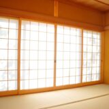 A photo of large sliding shoji screens in a traditional Japanese room with soft natural light filtering through the paper panels.