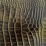 A detailed close up of crocodile leather featuring small dorsal scale patterns.