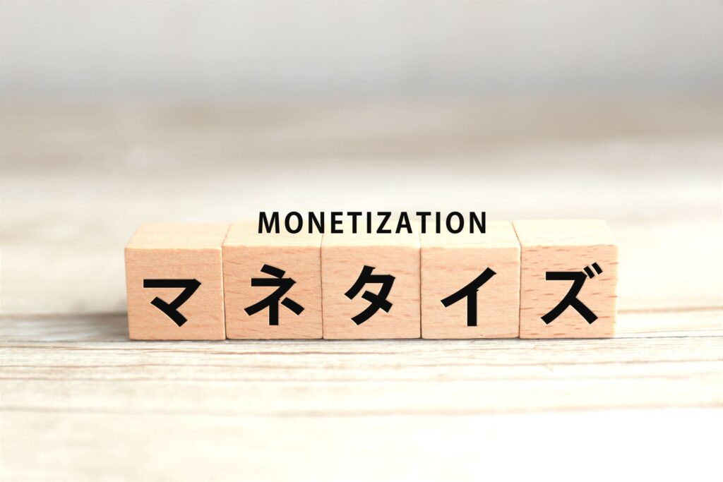 木製ブロックに「マネタイズ」の文字と、その上に「MONETIZATION」の英字が添えられた、コンテンツ販売の収益化をイメージさせる写真。
