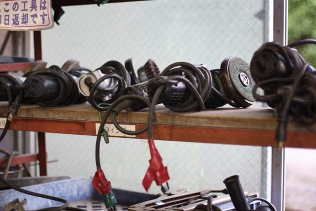 コンクリートの研磨や切断に使用するグラインダー（サンダー）が並ぶ、工事現場の工具整理棚