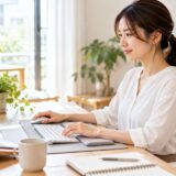Woman working at a computer in a home office, illustrating everyday activities that can put strain on the wrists.